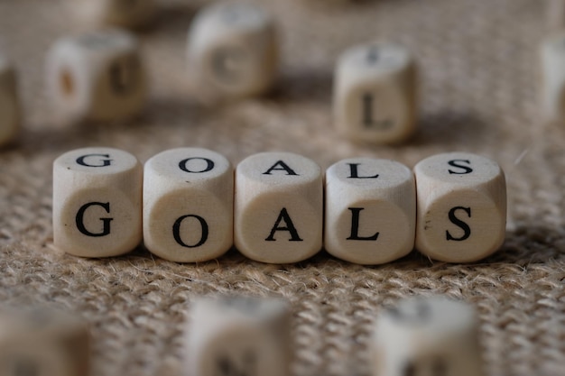 goals word concept on wooden cubes blocks on burlap background.