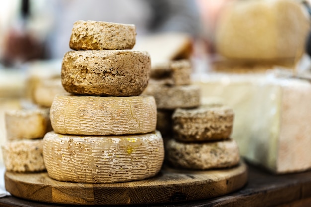 Goat cheese heads stacked on wooden plate