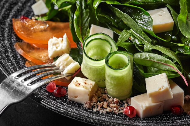 Салат из козьего сыра и хурмы с зеленью, огурцами, гранатом, грецкими орехами