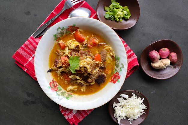 Goat Curry or gulai kambing food from asia Delicious goat meat curry served in a bowlserved with tomato seasoning celery and cabbage