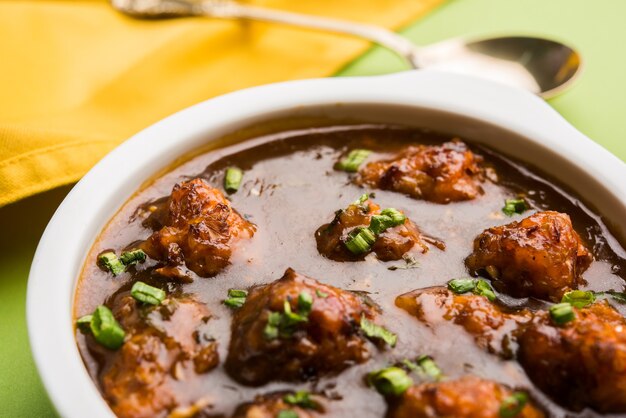 Gobi Manchurian dry or with gravy - Popular street food of India made of cauliflower florets, selective focus