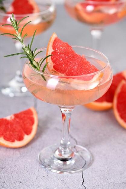 Goblet of sparkling wine with a slice of grapefruit and a sprig of rosemary