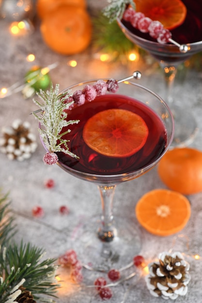 Goblet with cranberry Margarita with candied cranberries, rosemary and tangerine. Perfect cocktail for a Christmas party