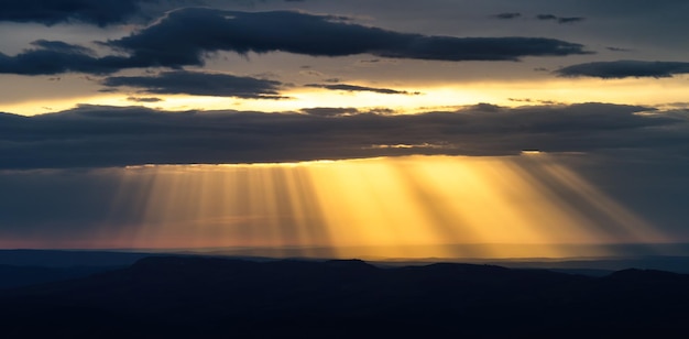 God rays coming through sunset clouds background