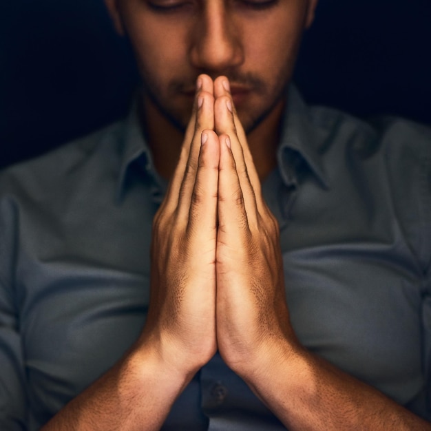 Photo god worship and man with hands praying for help hope and guidance in dark studio pray thank you and christian male in prayer for hope gratitude and holy praise faith or blessing to jesus christ