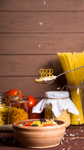 Goed eten is bekleed met pasta op een lepel in de buurt van een bord