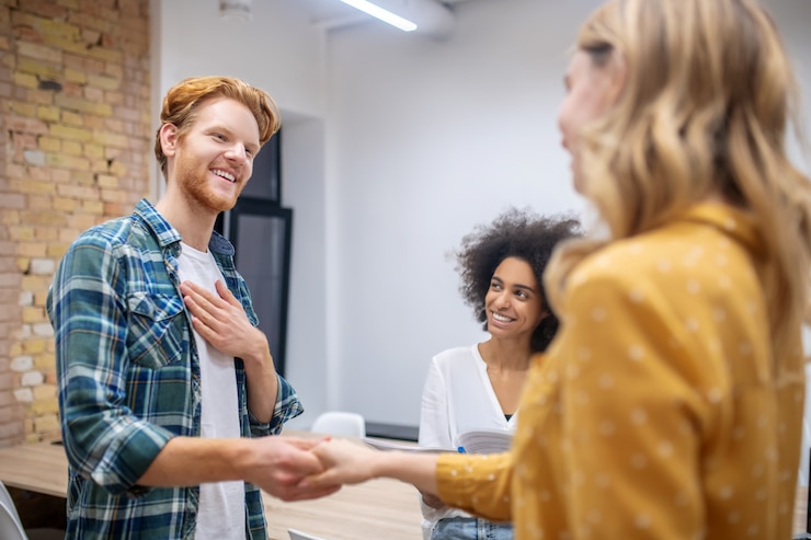 Foto goed gezind. groep jonge professionals die een nieuwe collega ontmoeten en gelukkig kijken