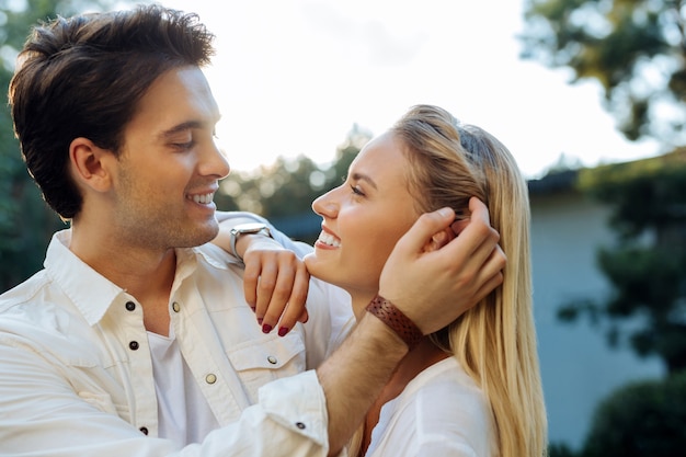 Foto goed humeur. vrolijke aardige vrouw die lacht tijdens het kijken naar het gezicht van haar man