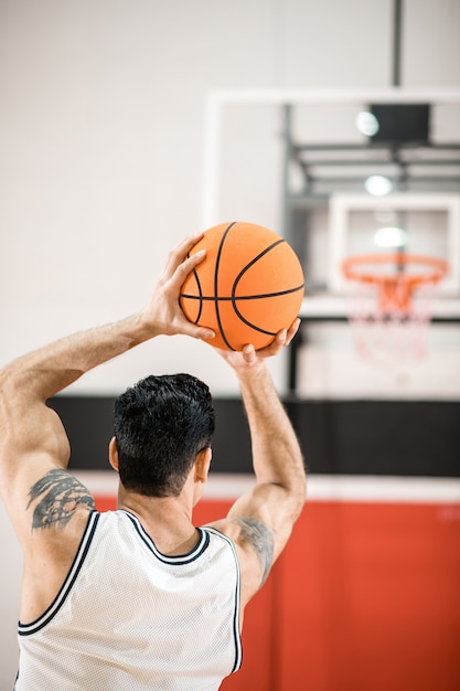 Goed resultaat. donkerharige basketbalspeler gooide een bal in de ring