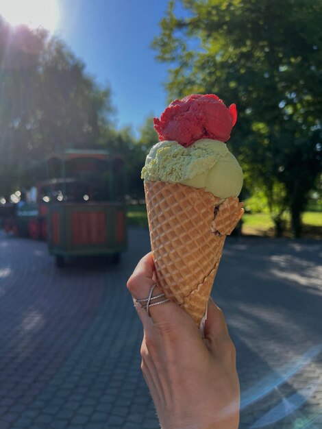 Goed uitziend ijs erop op een zonnige zomerdag in de hand van een vrouw