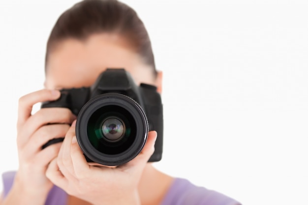 Goed uitziende vrouw met behulp van een camera tijdens het staan