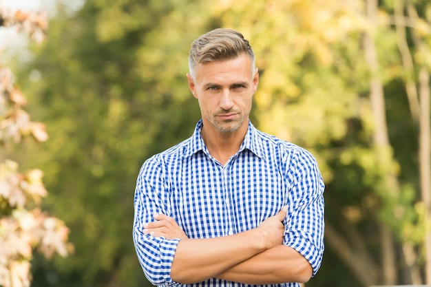 Goed verzorgd haar. casual man in geruit overhemd. mannelijke schoonheidsnormen. casual mode voor mannen. juiste kapperszaak maakt uw toekomst. grijze haarverzorging. volwassen man met gekruiste handen. vol vertrouwen.