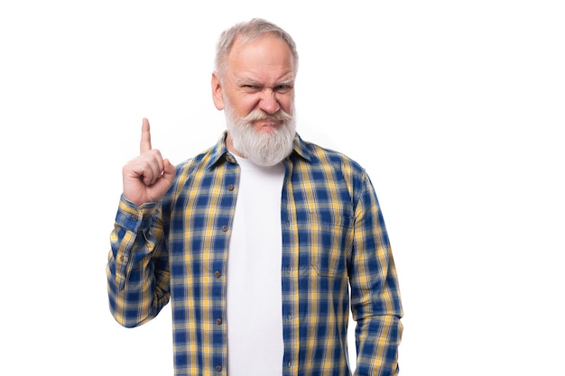 Goed verzorgde grijsharige gepensioneerde man van middelbare leeftijd met een snor en baard wijst met een vinger naar