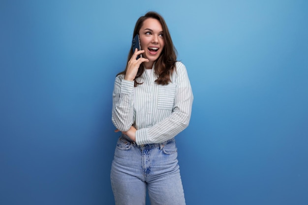 Goed verzorgde oude bruinharige vrouw die aan de telefoon praat.