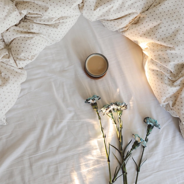 Goedemorgen gezellige compositie met koffiekopje blauwe bloemen in bed