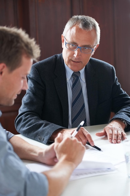 Photo going over assets shot of two colleagues discussing paperwork together