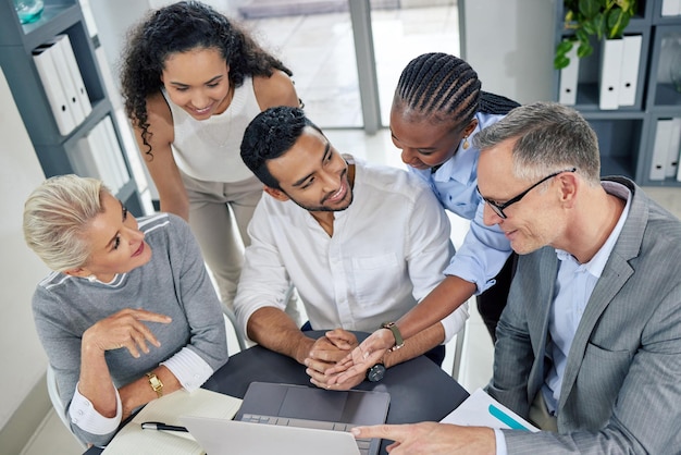 Going above and beyond to make their plans work Shot of a group of businesspeople using a laptop together in an office