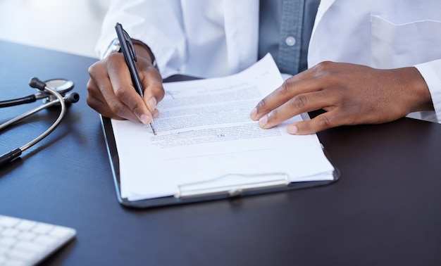 Going over some paperwork Closeup shot of a male doctor filling out paperwork