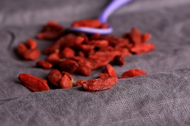 Goji berries on a dark linen background selective soft focus