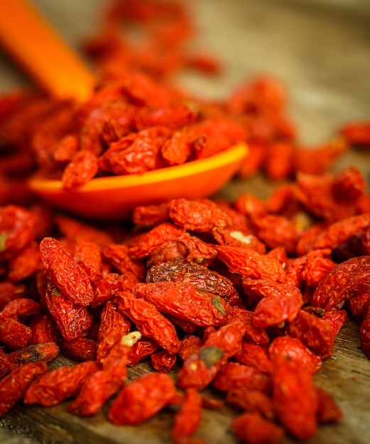 Bacche di goji in un cucchiaio su una tavola di legno