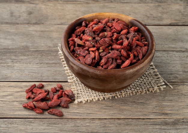 Goji berry in a bowl over wooden table.
