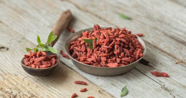 Goji in kom op houten tafel.