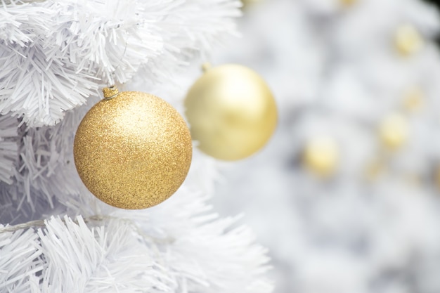 Фото Золотой шар на белой ветке рождественского дерева фоне