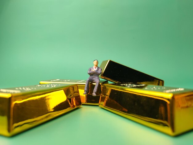 Gold bar with miniature people Business and financial concept