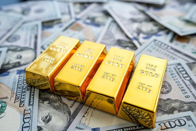 Золотые слитки над долларовыми купюрами концепция экономии инвестиций