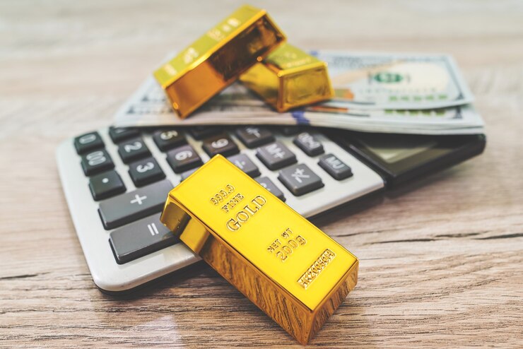 Photo gold bars with calculator and dollars
