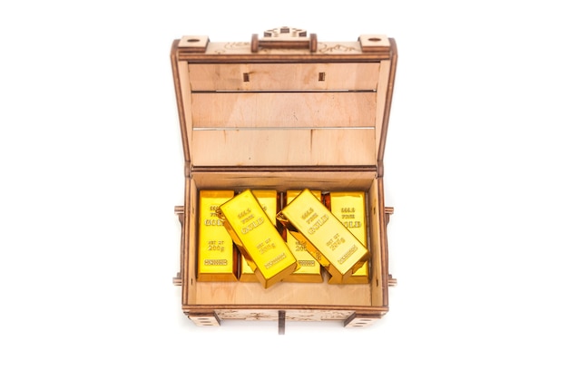 Photo gold bars in a wooden chest isolated.