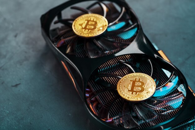 Photo gold bitcoin on the video card cooler on a dark background