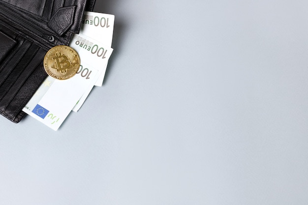 灰色の背景に財布とユーロとゴールドのビットコイン