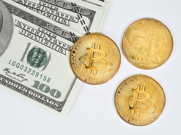 Bitcoin d'oro con lo sfondo bianco dei soldi del dollaro