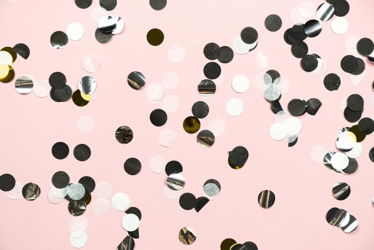 Gold black and white confetti on a pink background Party concept