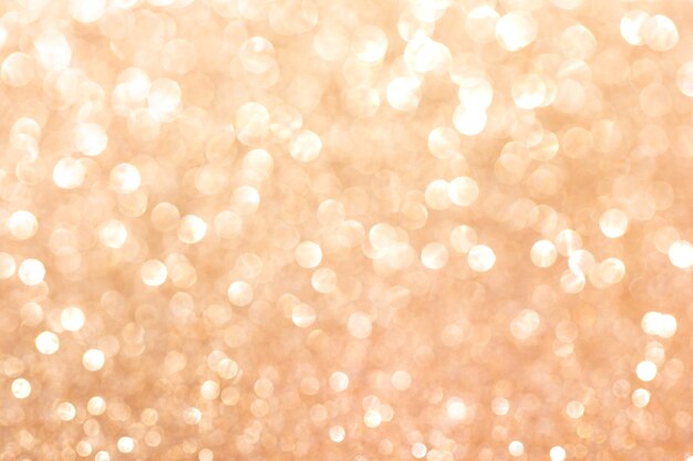 Золотой блеск размытым фоном. Сверкающая и блестящая текстура для рождественских и новогодних праздников или сезонного украшения обоев