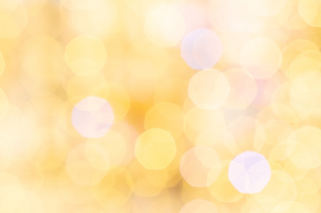 Gold bokeh background. Abstract glitter festive blur lights. Soft yellow christmas backdrop.