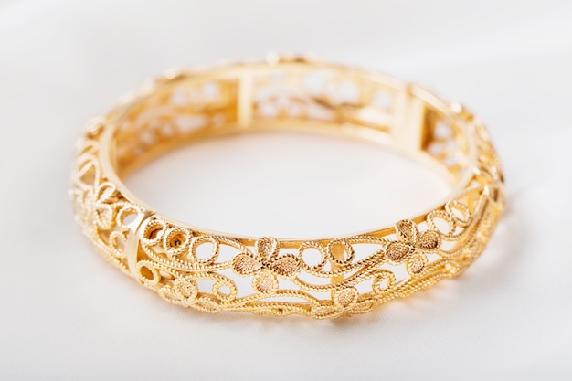 Gold bracelet on white cloth