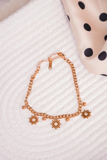 A gold bracelet with a chain that says sunflowers on it.