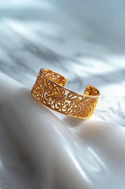 Gold bracelet with filigree design on marble