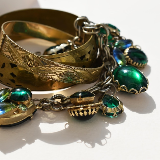 a gold bracelet with a green crystal