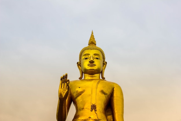 The gold buddha statue is on the sky background