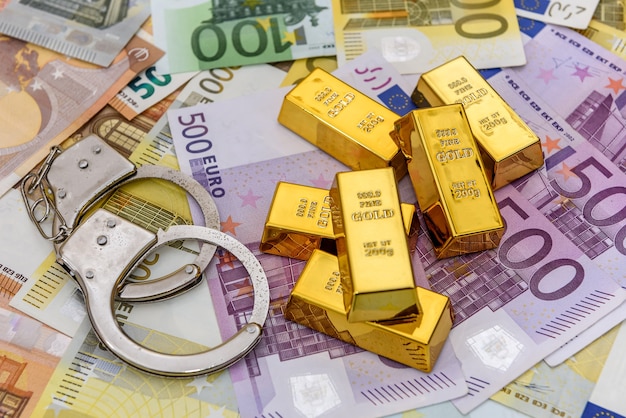 Gold bullions with handcuffs at euro banknotes