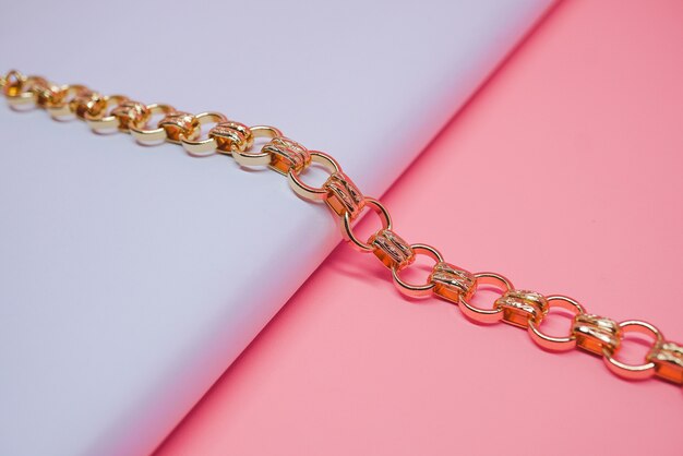 gold chain bracelet with peach color background