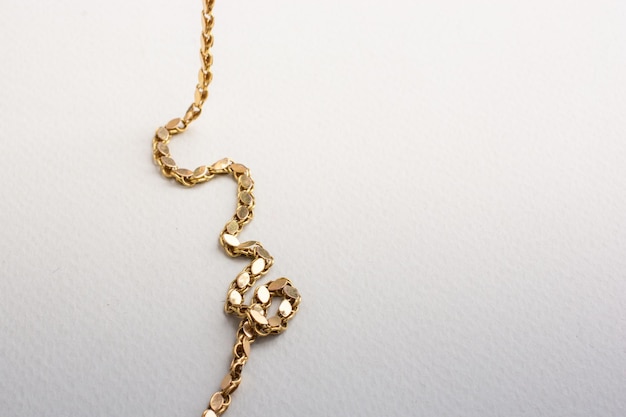 Gold chain laid out on white background