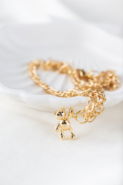 Gold chain with a bear on a light background