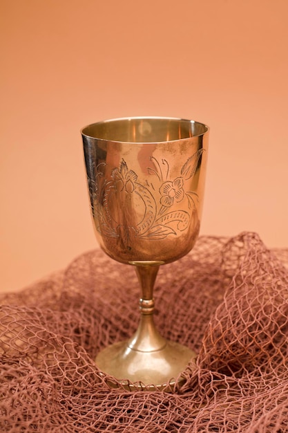 Photo gold chalice with fishing net on brown background