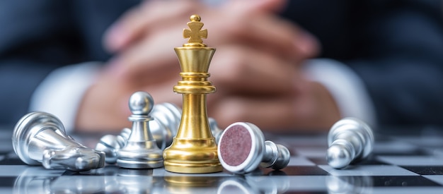 Gold Chess King figure stand out from crowd of enermy or opponent during chessboard competition.