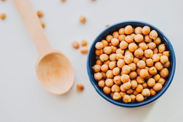 Gold chickpeas in bowl with wooden spoon