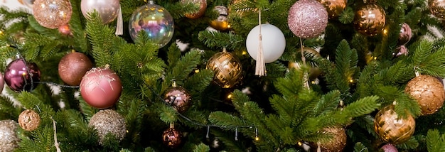 Gold Christmas ball on a Christmas tree in a light interior against the background of burning garlands of lights Decorating Christmas tree Happy holidays Web banner